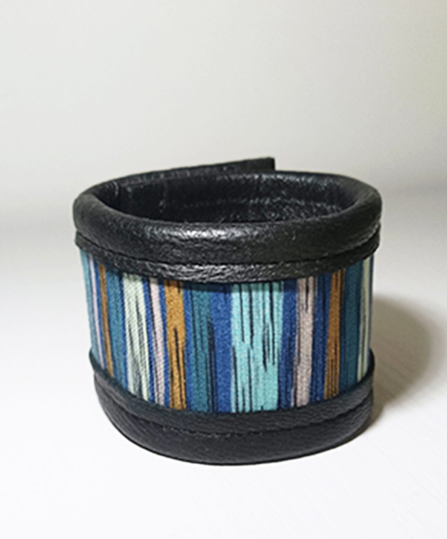 A black leather wrap bracelet with a central insert of colourful striped fabric in the Missoni style.