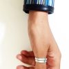 Bracciale a fascia in pelle nera con inserto centrale in tessuto a righe colorate stile Missoni.