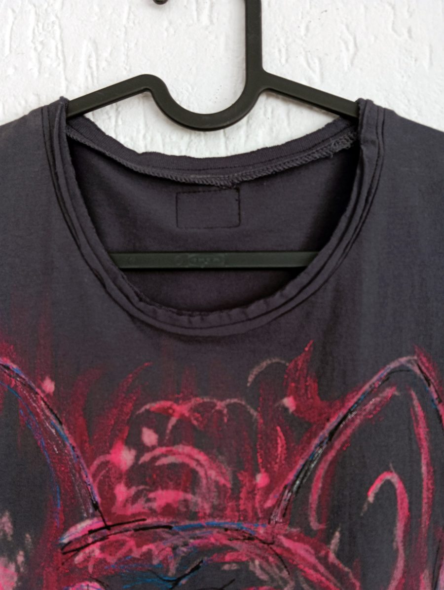 Detail of the round neckline and the upper part of the hand-painted design depicting the ears of a French bulldog on anthracite-coloured fabric