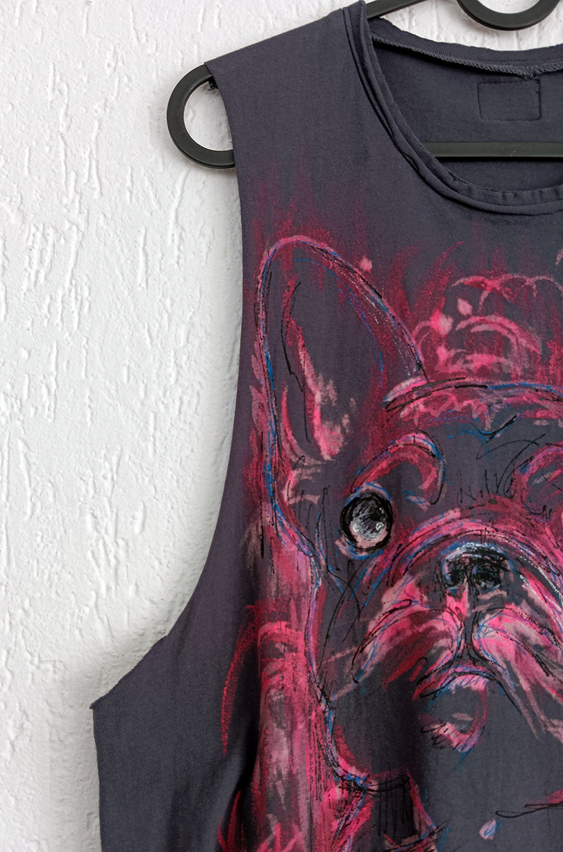 A close-up view of the wide armholes and the shades of pink and red painted onto the handmade, artistic vest.