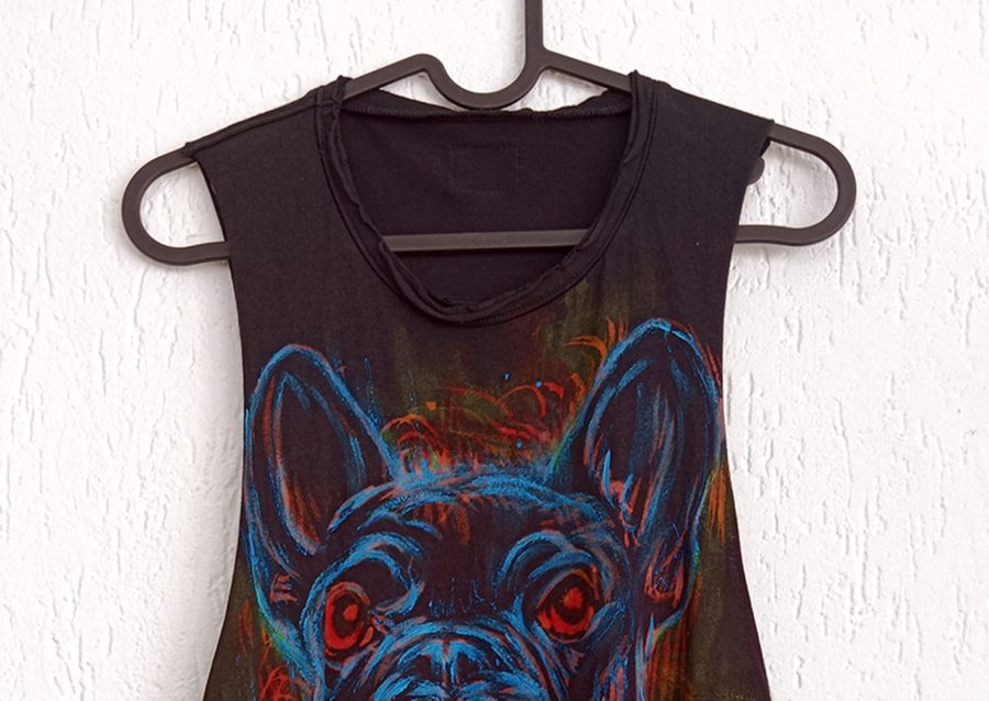 Particolare dello scollo tondo e della parte superiore del dipinto a mano raffigurante le orecchie di un bulldog francese su tessuto nero